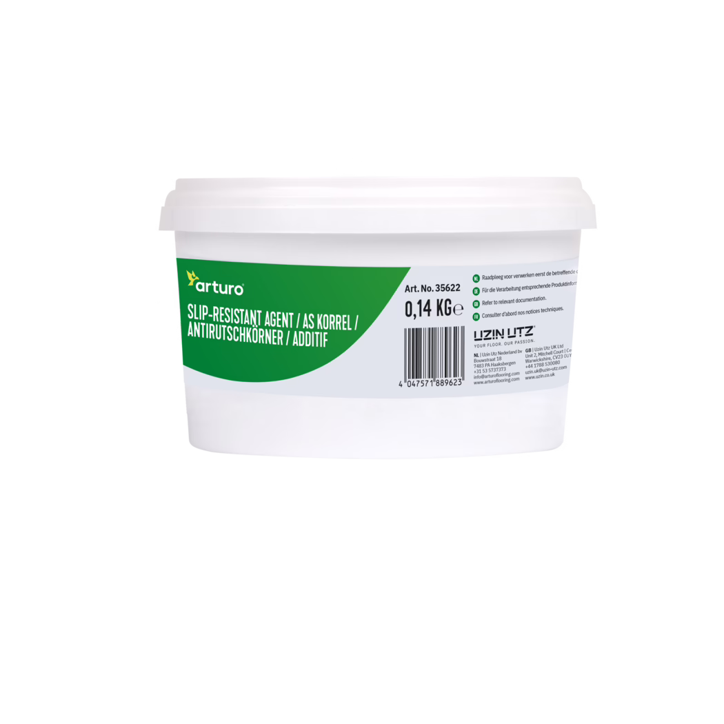 Arturo_Dummy_slip-resistant agent-0,1375kg_2022-05 Gros plan sur la moitié supérieure d'un seau en plastique blanc avec une étiquette verte et grise d'Arturo indiquant « Slip-Resistant Agent », la mention 0,14 kg, un code-barres et de petites instructions multilingues ; le récipient est présenté sur un fond blanc uni.